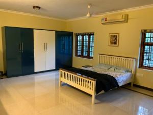 a bedroom with a bed in a room with yellow walls at "Rohini Villa" 5 Bedroom Luxury Garden Villa in Kozhikode in Māvūr