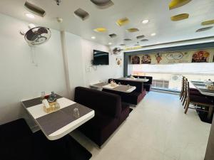 a restaurant with couches and tables and a dining room at RRA Retreat Hotel , Best Hotel in Nathdwara Near Shrinathji Mandir in Nāthdwāra