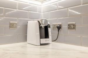 - une machine à café assise sur un comptoir dans une pièce dans l'établissement Large Modern Penthouse - 4 Beds 3 Baths by Tower Bridge, à Londres