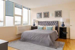 une chambre avec un grand lit et deux fenêtres dans l'établissement Large Modern Penthouse - 4 Beds 3 Baths by Tower Bridge, à Londres
