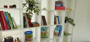una estantería blanca con libros y una maceta en Ferienhaus Arno - Thüringer Wald, en Waltershausen