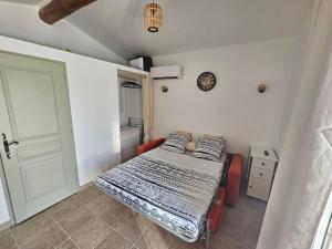 a bedroom with a bed and a clock on the wall at Studio Vu sur l'O2 Là in La Motte