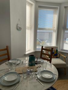a dining room table with plates and glasses on it at Seaside Escape, Central Portrush Apartment in Portrush +8 photos