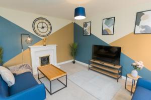 un salon avec un canapé bleu et une télévision dans l'établissement Perfect for Contractors & Families & Free Parking, à Stafford