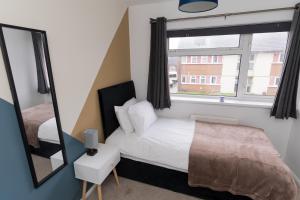 une chambre avec un lit, un miroir et une fenêtre dans l'établissement Perfect for Contractors & Families & Free Parking, à Stafford