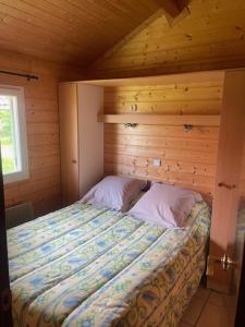 una camera da letto con un letto in una cabina di legno di L'Auberge Saint Santin Cantales a Saint-Santin-Cantalès