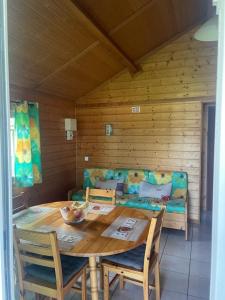 una stanza in legno con un tavolo, sedie e un divano di L'Auberge Saint Santin Cantales a Saint-Santin-Cantalès