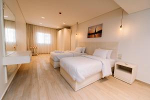 a hotel room with two beds and a television at Zones Residence Maadi in Cairo
