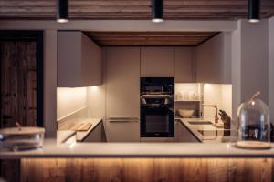 a kitchen with white cabinets and a counter top at Antarès SIRIUS 101 - Prestigious ski inski out apartment in Méribel