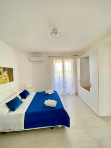 una camera con letto blu e bianco e TV di Mia House - Appartamento Marzamemi a Marzamemi