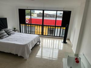 ein Schlafzimmer mit einem Bett und einem großen Fenster in der Unterkunft El refugio in Pereira + 2 Fotos