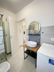 un bagno con lavandino e specchio di Mia House - Appartamento Marzamemi a Marzamemi