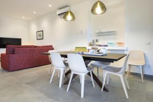 une salle à manger avec une table et des chaises blanches dans l'établissement La Casa diLà sul Mare, à Acireale