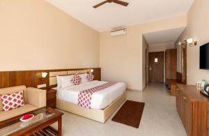 una camera da letto con un letto, un divano e una televisione di Kumbhal Exotica Resort Kumbhalgarh a Kumbhalgarh