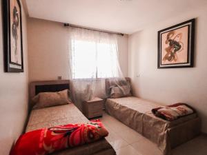 Un dormitorio con dos camas y una ventana. en Luxury and Comfort-Chic Apartment, en Agadir 11 fotos más