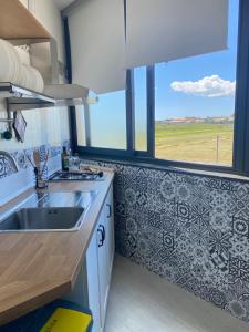 una cucina con un lavello e una grande finestra di Mia House - Appartamento Marzamemi a Marzamemi