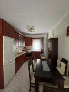 a kitchen with a black table and a white refrigerator at Lia Apartments 1 in Kallithea Halkidikis