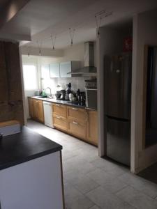 a kitchen with wooden cabinets and a stainless steel refrigerator at LES GITES CHEROIS maison familiale 13 personnes in Les Chères