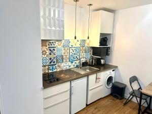 een keuken met een spoelbak en een wasmachine bij HSH - LE CHAPELAIS CLICHY MONTMARTe in Parijs +5 foto's