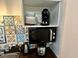 een kast met een koffiezetapparaat in een keuken bij HSH - LE CHAPELAIS CLICHY MONTMARTe in Parijs