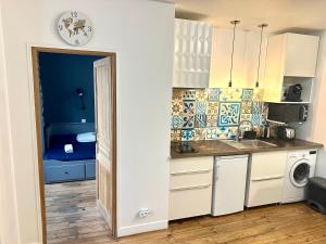 een keuken met een spoelbak en een wasmachine bij HSH - LE CHAPELAIS CLICHY MONTMARTe in Parijs