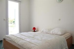 a white bed in a room with a window at Appt 2 pièces LA ROCHELLE - LR030-E16 in La Rochelle +2 photos