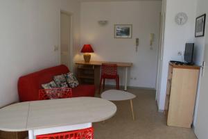 a living room with a red chair and a table at Appt 2 pièces LA ROCHELLE - LR030-E16 in La Rochelle