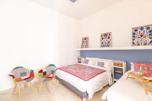 a bedroom with a bed and two chairs at Elsa d'Ortigia in Siracusa