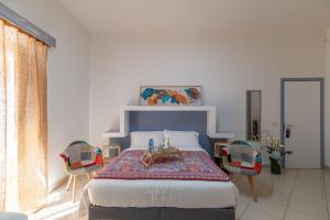 a bedroom with a bed with a table and chairs at Elsa d'Ortigia in Syracuse