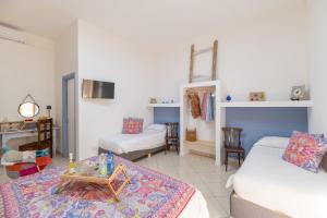 a living room with two beds and a table at Elsa d'Ortigia in Syracuse