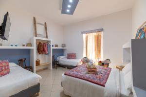 a bedroom with two beds and a table in it at Elsa d'Ortigia in Syracuse