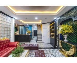 a living room with a red couch and a staircase at Dancentre Airport Stays - Vyvy Hotel in Ho Chi Minh City