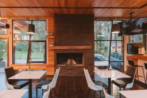 a living room with tables and a fireplace at Puerto Dijama Hotel Boutique in Carmelo