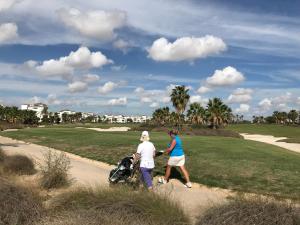 two people walking down a path near a golf course at Arty Apartment - La Torre Golf Resort in Torre-Pacheco