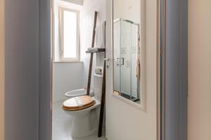 a white bathroom with a toilet and a window at Elsa d'Ortigia in Siracusa +40 photos