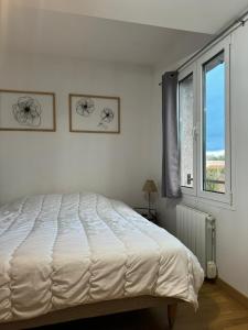 a white bedroom with a bed and a window at LES GITES CHEROIS maison esprit campagne 6 personnes in Les Chères