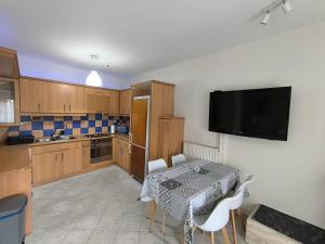 a kitchen with a table and a television on the wall at Cozy Houses One Apartment Hydromassage & Terrace in Kavála