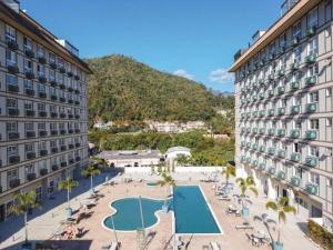 an aerial view of a resort with a swimming pool at Charmoso Flat na Serra - Granja Brasil Itaipava in Itaipava