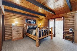 una camera da letto in stile baita di tronchi con letto e soffitto in legno di Aim True North a McCall
