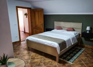 a bedroom with a large bed and a green wall at Casa Purcărean in Întorsura Buzăului