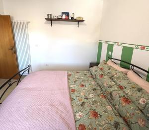 a bedroom with a bed with a green and pink bedspread at Bosco Stellato in Casteldelci