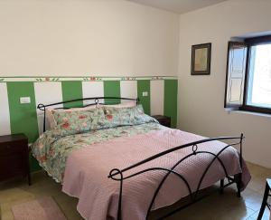 a bedroom with a bed with a green and white headboard at Bosco Stellato in Casteldelci +24 photos
