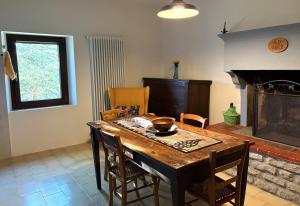 a dining room with a table and a fireplace at Bosco Stellato in Casteldelci