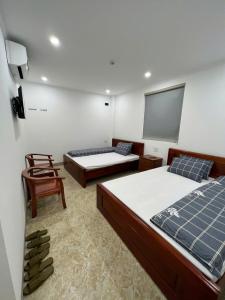 a room with two beds and a tv and a chair at Bich Phuong Hotel 6 in Làng Lap