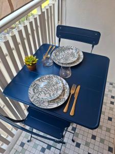 a blue table with plates and utensils on it at Artistika on the beach in Bibione