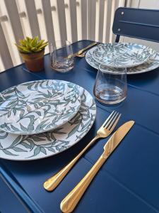 a blue table with two plates and forks and glasses at Artistika on the beach in Bibione +17 photos