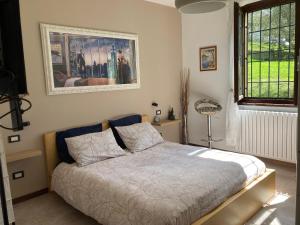 a bedroom with a bed and a picture on the wall at Villa Vinea Prisca B&B - Bergamo Hill in Cenate Sotto