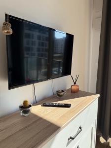 a tv on top of a dresser with a remote control at A63 by Real Apartment in Warsaw
