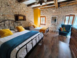 a bedroom with two beds and a stone wall at Stancija Negričani in Divšići +66 photos