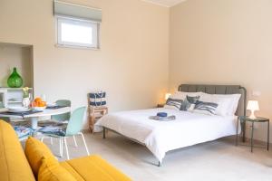a bedroom with a bed and a table and a couch at L'Arancio e i Pesci Rossi in Calatabiano